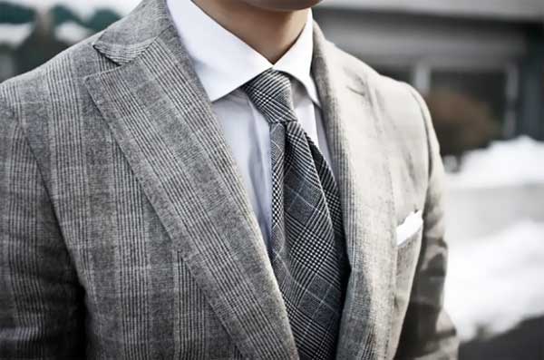 Checkered style grey tie matches the chequered grey suit