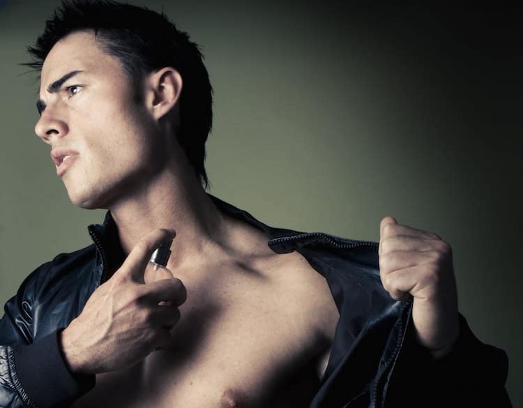 muscular handsome Man with perfume bottle wearing