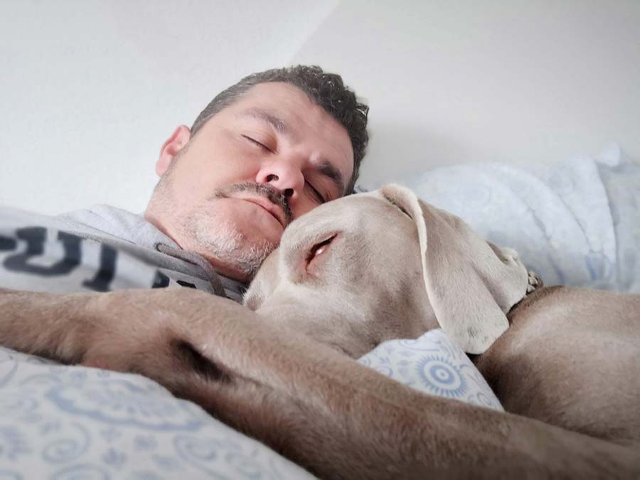 man sleeping with his dog