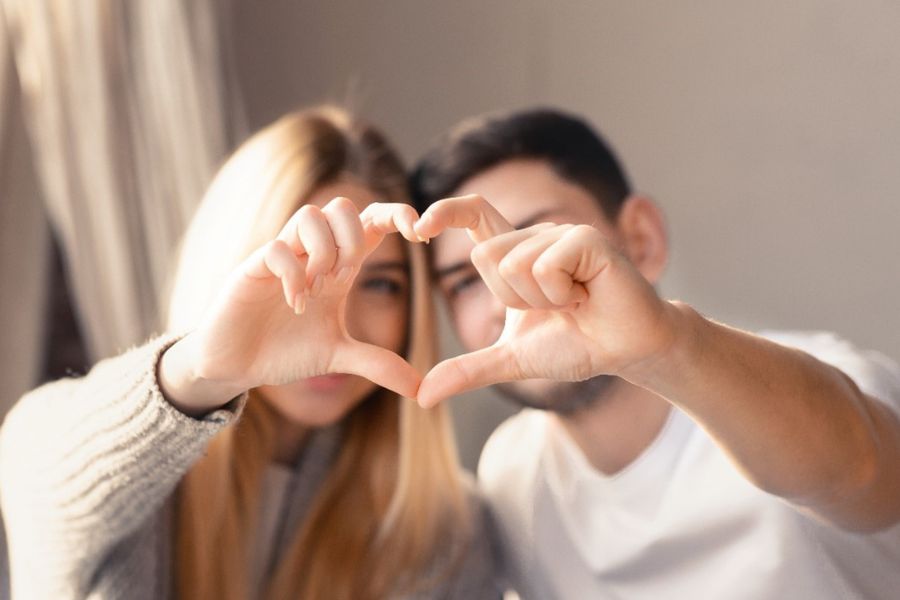 a young couple making a heart symbol